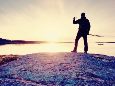 Cep telefonu dijital kamerada şaşırtıcı deniz manzara fotoğrafını çekmek turist adam.