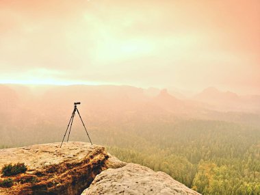 Tripod üzerinde tepe photogrpahy için hazır. Kayalık bakış maruz. Puslu yağmurlu sonbahar gün