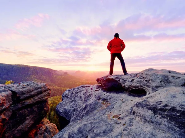 The figure of the men in red jacket on sharp cliff. Mountains within early fall daybreak — Stock Photo, Image