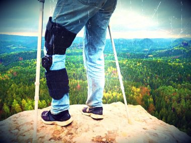 Hareketsiz ve desteklemek için bir dizlik ayarlanabilir yan paneller ile giyen adam turist bacak zarar. Againts koltuk değneği yürüyen adam