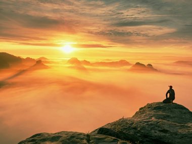 Yalnızlık üzerine maruz kayalık zirve anı. Siyahlı adam muhteşem görünümü keyfini çıkarın. Uzun yürüyüşe çıkan kimse sit tepe üzerinde