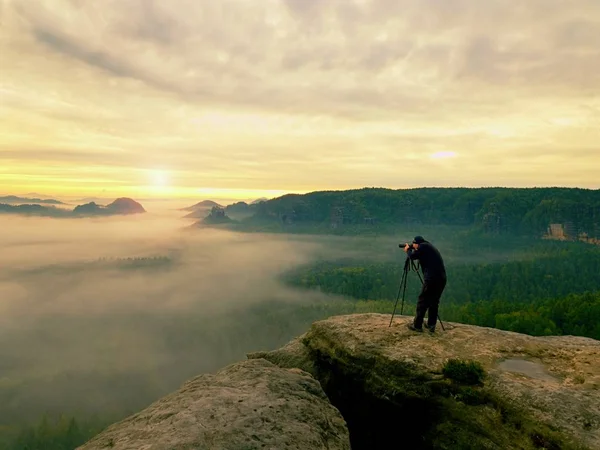 Fotoğrafçı siluet bir bulutlar deniz, Puslu dağlar yukarıda — Stok fotoğraf