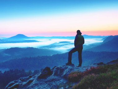 Uzun yürüyüşe çıkan kimse kayaya dikkat et kremsi mista ve sisli sabah peyzaj üzerinde.