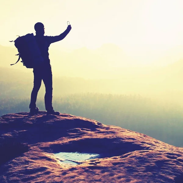 Man takes photos with smartphone in morning misty  mountains — Stock Photo, Image