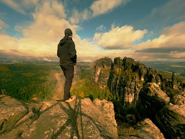 Турист на скале над долиной. Человек следит за туманной и осенней утренней долиной к яркому утру нигде . — стоковое фото