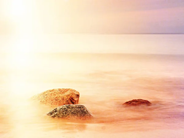 Larga exposición del mar y grandes rocas que sobresalen del agua en el crepúsculo . — Foto de Stock