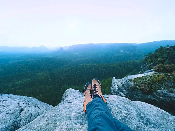 Homem cansado caminhante deitar e desfrutar de vista para a paisagem sobre suas pernas cansadas em botas turísticas — Fotografia de Stock