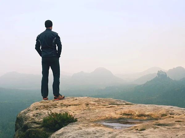 Hiker in sportswear stand on the peak of sandstone rock in rock empires park and watching over vallley — Stock Photo, Image