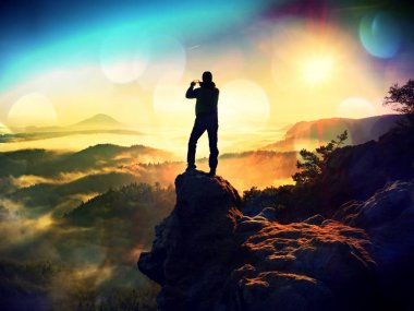 Telefonu el ile uzun boylu backpacker selfie yapar. Güneşli bahar daybreak dağlarda.