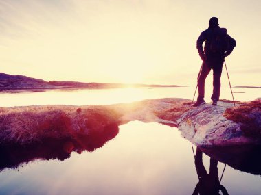 Uzun boylu backpacker deniz üzerinde açık güneşli gün doğumuna bak. Uzun yürüyüşe çıkan kimse uzun yürüyüşe çıkan kimse nefes kesici gündoğumu zevk