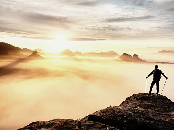 Silhouette uomo con pali in mano. Sunny vacanze primaverili e guida turistica soggiorno sulla scogliera tagliente di montagna . — Foto Stock