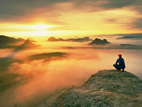 Alone escursionista in rosso cap stand sulla cima di roccia arenaria nel parco imperi rocciosi e guardando la nebbia — Foto Stock