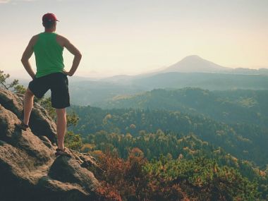Turizm yeşil singlet ve siyah şort, Rock'da doğa sahne tadını çıkarın. Güneş banyosu vadide