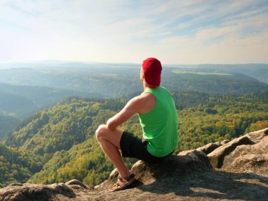 Turizm yeşil singlet ve siyah şort, Rock'da doğa sahne tadını çıkarın. Güneş banyosu vadide