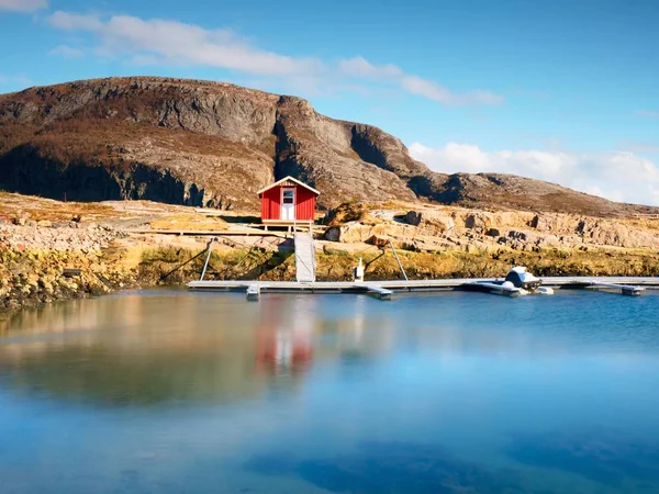 Maison de bateau rouge au quai, île rocheuse, Norvège. Bâtiment traditionnel blanc rouge au quai près de la mer — Photo