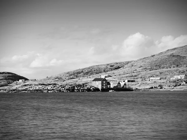 Традиційне рибальське село. Котеджі на узбережжі скелястого острова. Червоно-біла будівля сяє — стокове фото