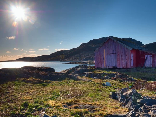 典型的な赤い家とノルウェーの海岸の風景です。海辺の木製の赤い家 — ストック写真