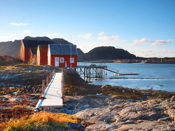 Traditionelles Fischerdorf. Ferienhäuser an der Küste auf der Felseninsel. Rot-weißes Gebäude glänzt — Stockfoto