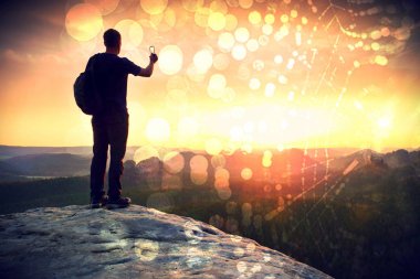 Telefonu el ile uzun boylu backpacker selfie yapar. Güneşli bahar daybreak dağlarda.