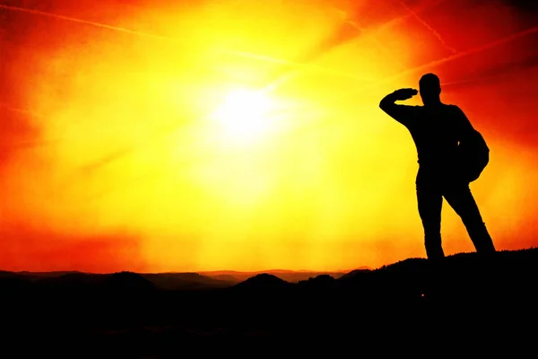 Man shadowing eyes. Alone tourist on cliff edge and watching into deep valley bellow. — Stock Photo, Image