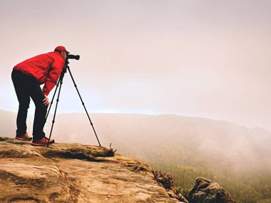Dağ tepe üzerinde profesyonel fotoğrafçı iş. Doğa fotoğrafçısı rock ayna kamera ile fotoğraf çeker 