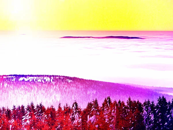 . Рожеве оранжеве сонце піднімається над туманними зимовими горами, сяючим туманом. Піки гір — стокове фото