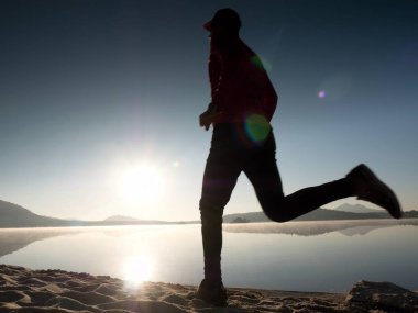 Uzun kumsalda hızlı deniz kıyısında koşan adam uygun. Güçlü runner yaz sabah açık eğitim.