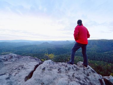 Yalnız turist kap ve sportif açık giysiler ile stand Milli Parkı vadiye izlerken uçurumun kenarında