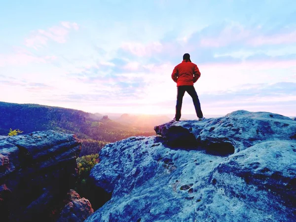 Alone tourist with cap and sporty outdoor clothes stand on cliff edge watching into national park valley — Stock Photo, Image