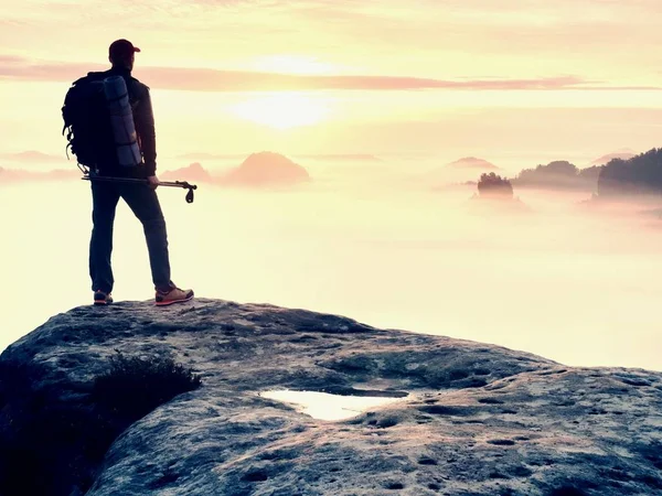 Silhouette uomo con pali in mano. Sunny vacanze primaverili e guida turistica soggiorno sulla scogliera tagliente di montagna . — Foto Stock