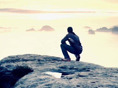 Yalnızlık üzerine maruz kayalık zirve anı. Siyahlı adam muhteşem görünümü keyfini çıkarın. Uzun yürüyüşe çıkan kimse sit tepe üzerinde