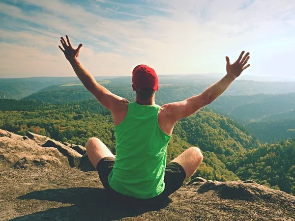 Hombre sentado en la cima de la montaña en pose de yoga. Ejercicio de yoga en el borde con una vista impresionante — Foto de Stock