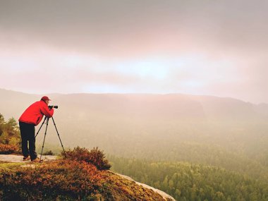 Dağ tepe üzerinde profesyonel fotoğrafçı iş. Doğa fotoğrafçısı rock ayna kamera ile fotoğraf çeker 