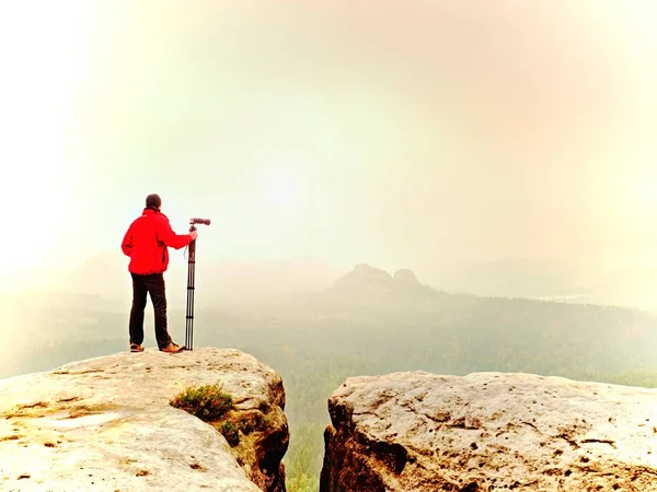Fotograf denken über Bild auf Gipfel in den nebligen Bergen nach. Tal im dichten Nebel versteckt — Stockfoto