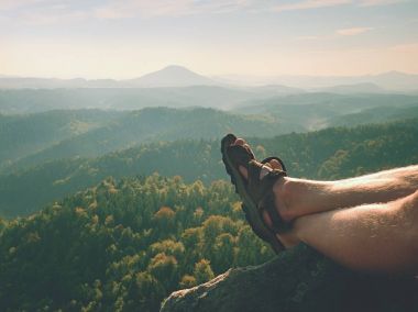 Sandalet peak hiking içinde uzun yorgun çıplak bacaklar. Kumtaşı kayalarda, dağlık manzara hiking