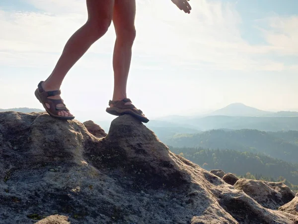 Largas piernas desnudas cansadas en sandalias de senderismo en pico. Senderismo en rocas de arenisca, paisaje montañoso — Foto de Stock