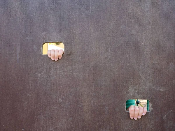 Mano bambini con piccole dita attraverso il foro in scala di legno parete arrampicata sul parco giochi per bambini — Foto Stock