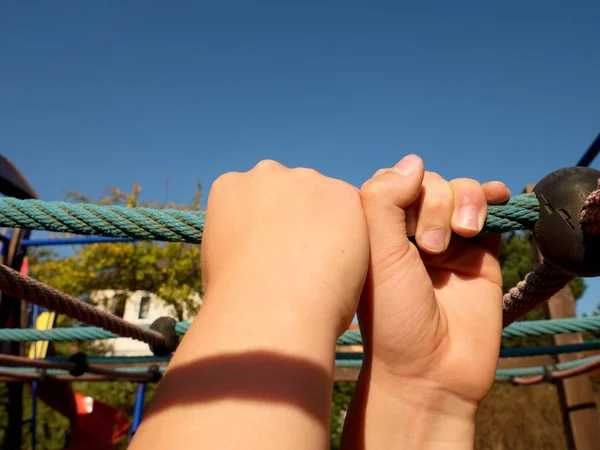 Niño sosteniendo en la barra de cuerda azul en el jardín infantil — Foto de Stock