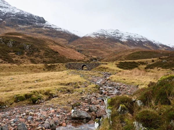 Día de niebla fría en las montañas de Higland primavera en Escocia. Cono nevado de montaña en nubes pesadas . — Foto de Stock