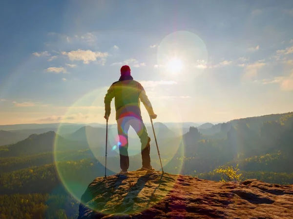 Turist med underarmen krycka ovanför huvudet på leden. Sårad hiker uppnåtts bergstopp — Stockfoto