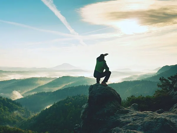 L'escursionista si riposa sulla vetta della montagna. L'uomo siede sulla cima tagliente e gode di una vista spettacolare . — Foto Stock