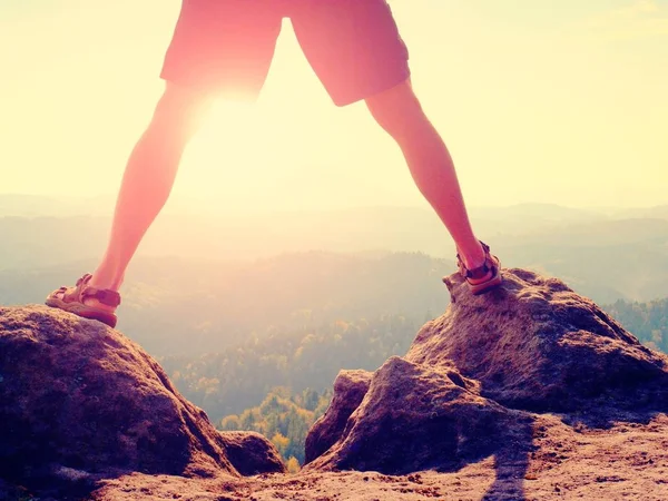 Step above jungle.  Sun between legs. Make naked legs  in pants and trekking sandals make step on rock — Stock Photo, Image