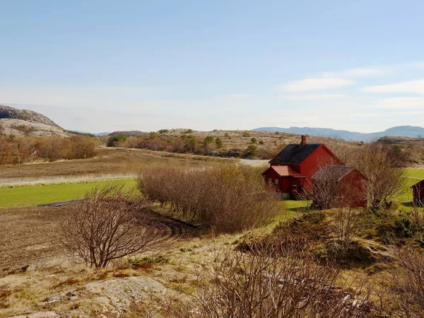 Une cabane traditionnelle en bois rouge soufflet colline rocheuse. Maison au design classique norvégien — Photo