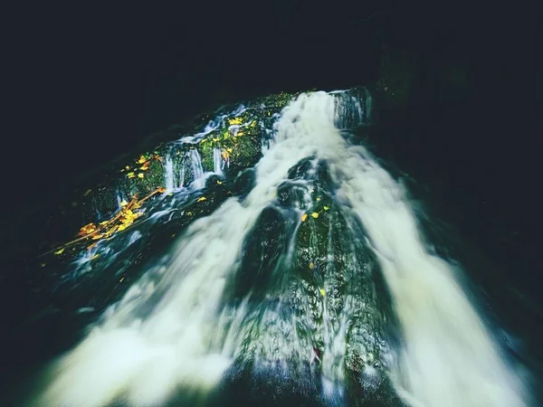 Light painting in night waterfall in autumn stream.  Blurred foamy water on mossy rock with colorful leaves. — Stock Photo, Image