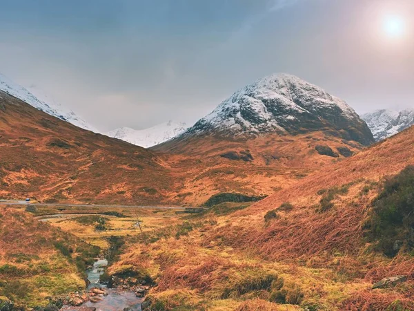 ストリームと石橋スコットランドの Higland 山を春します。重い雲の雪山. — ストック写真