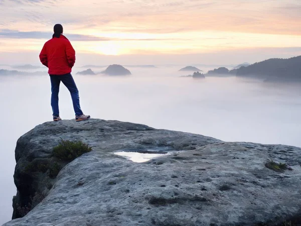 Człowiek turysta na szczyt góry. Cudowny brzask w jesień mglisty krajobraz. Słońce ukryte w chmurach — Zdjęcie stockowe