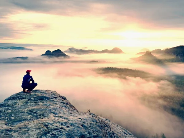 Moment of loneliness on exposed rocky summit. Man in black enjoy marvelous view. Hiker sit on the peak — Stock Photo, Image