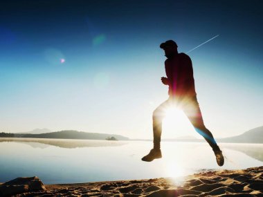 Adam güneş gözlüğü, Kırmızı beysbol şapkası ve siyah spor giyim çalışan ve kumsalda egzersiz kırmızı.