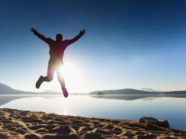 Adam güneş gözlüğü, Kırmızı beysbol şapkası ve siyah spor giyim çalışan ve kumsalda egzersiz kırmızı.