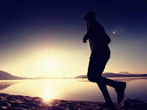 Exercício na praia ao pôr do sol, sol no horizonte — Fotografia de Stock